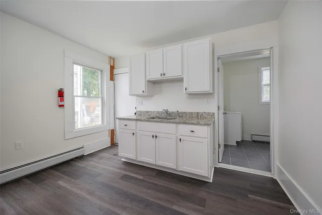a view of a small space with wooden floor and a window