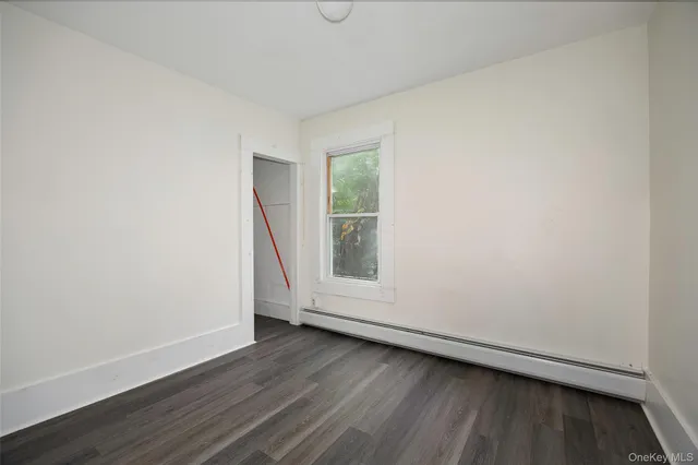 a kitchen with granite countertop a refrigerator a stove a sink and white cabinets with wooden floor