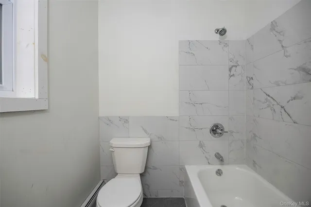a bathroom with a sink toilet and window