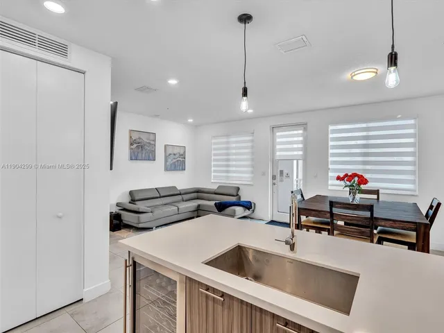 a kitchen that has a sink a stove and chairs