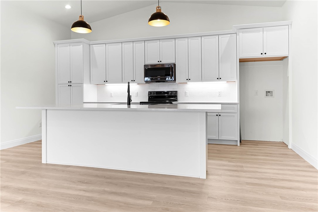 1210 West Dallas Seadrift, TX 77983 - Photo 18 of 21 a kitchen with kitchen island white cabinets and stainless steel appliances