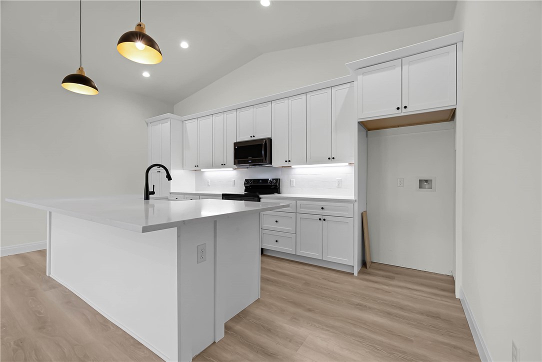 1210 West Dallas Seadrift, TX 77983 - Photo 5 of 21 a kitchen with cabinets stainless steel appliances and wooden floor
