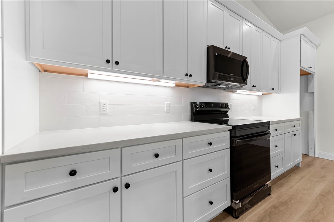 1210 West Dallas Seadrift, TX 77983 - Photo 8 of 21 a kitchen with white cabinets and black appliances