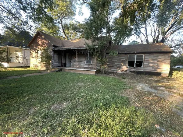a front view of a house with a garden and trees