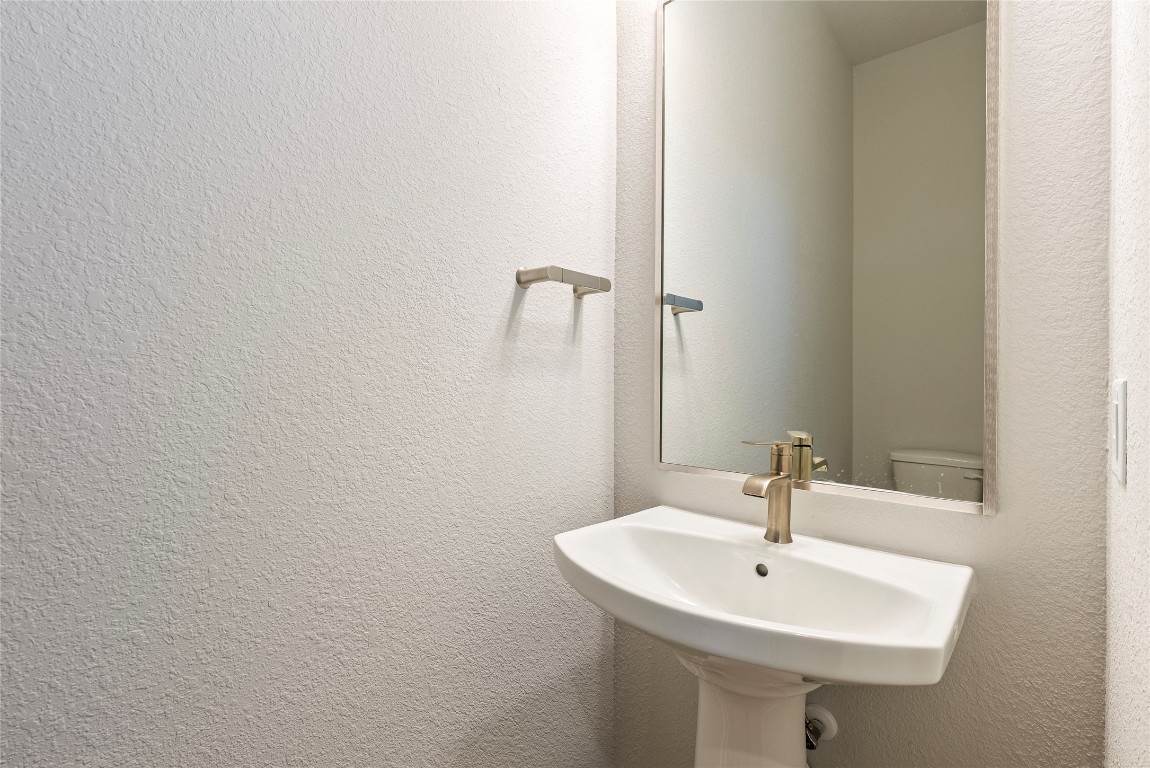 1057 Brickell Loop Austin, TX 78744 - Photo 8 of 33 a bathroom with a sink and a mirror