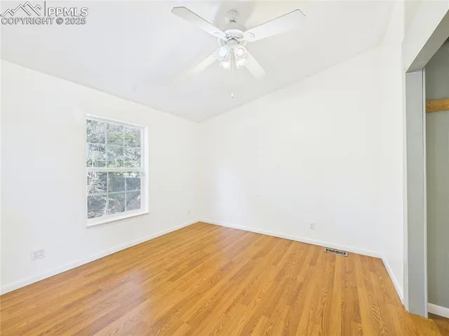 a view of empty room with wooden floor