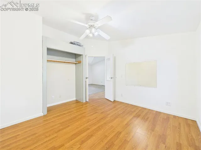 an empty room with a window and wooden floor