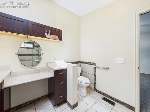 a large kitchen with granite countertop a stove a sink and a refrigerator