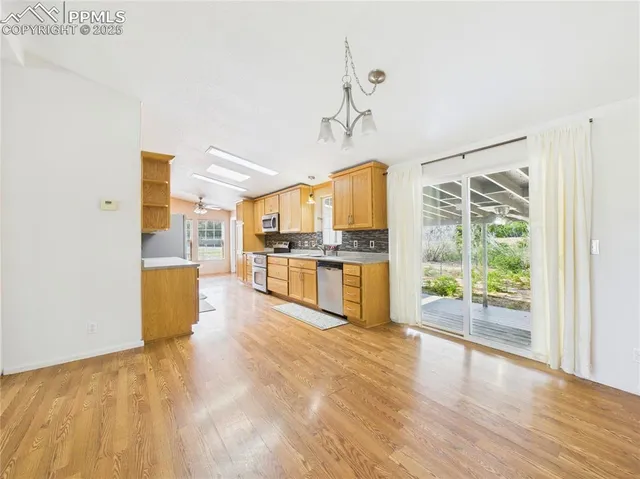 a view of a kitchen with wooden floor and a refrigerator