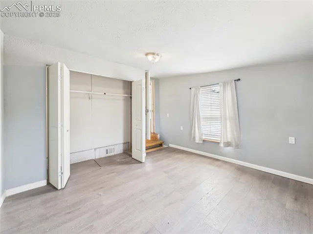 an empty room with windows and closet