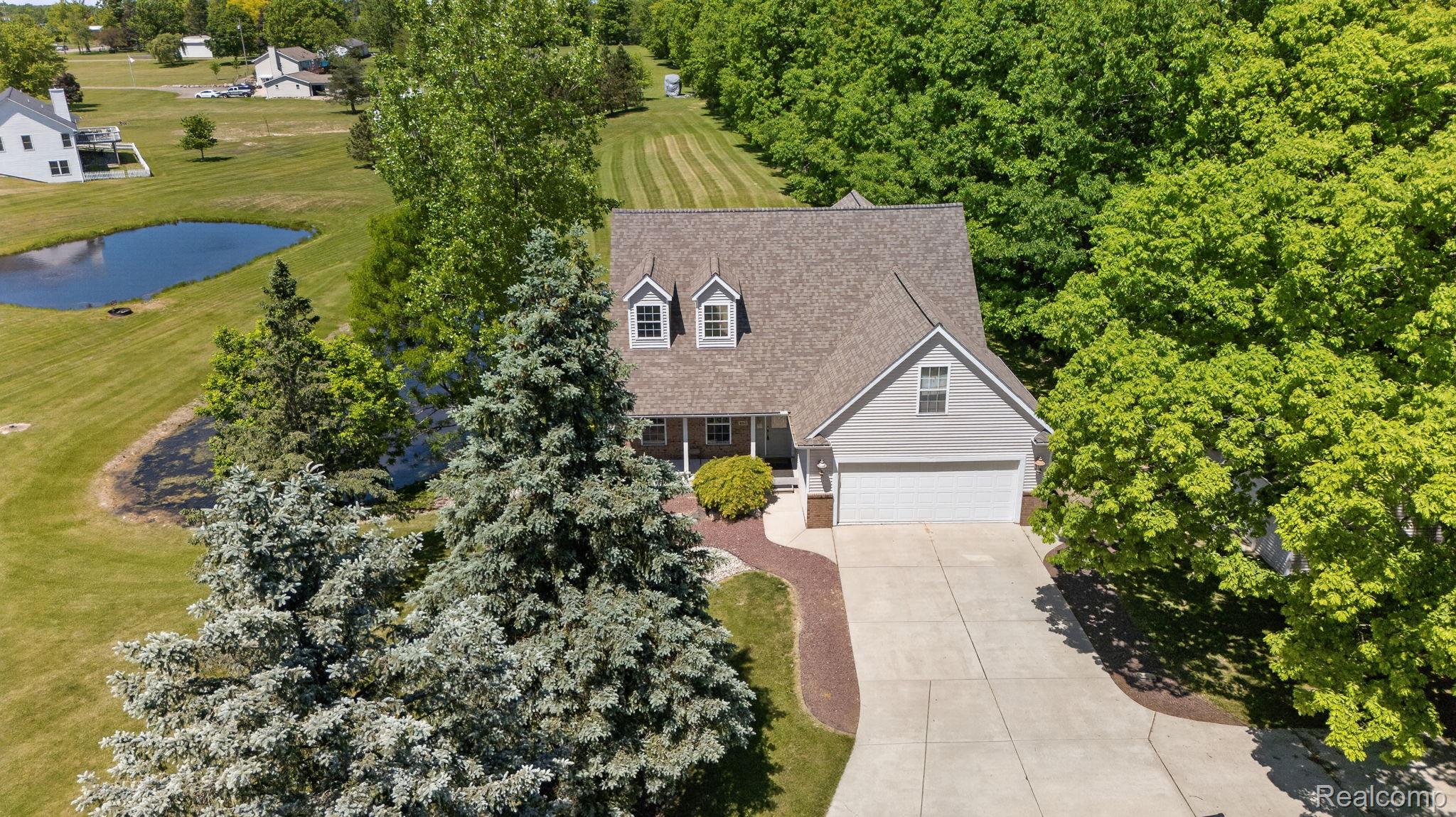 9055 Hegel Road Grand Blanc, MI 48439 - Photo 50 of 62 Traditional-style home featuring light gray siding, a gabled roof, and a two-car garage