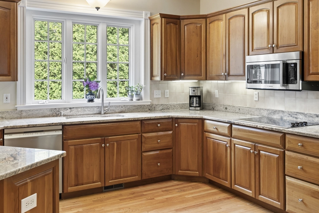 32 Bulkley Road Sudbury, MA 01776 - Photo 16 of 39 a kitchen with granite countertop wooden cabinets a sink and a window