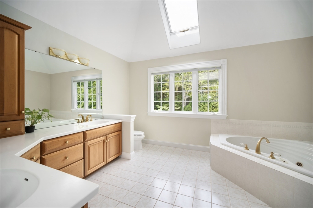 32 Bulkley Road Sudbury, MA 01776 - Photo 24 of 39 a large spacious bathroom with a tub a double vanity sink a mirror and a bathtub