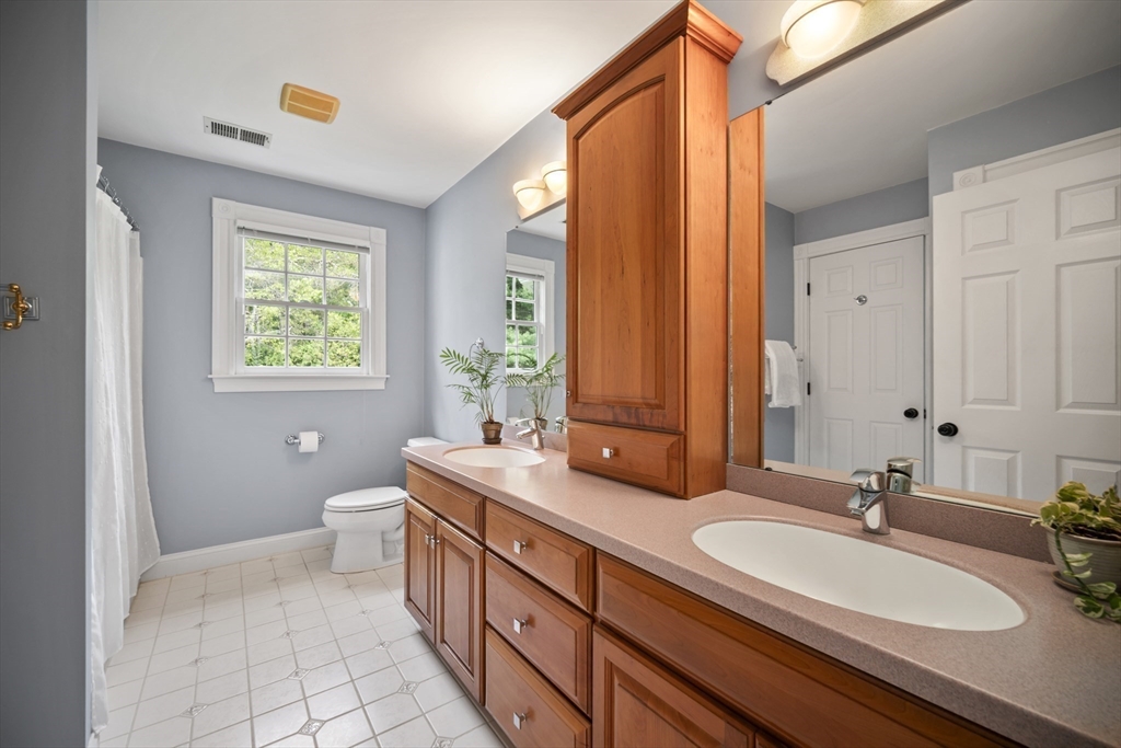32 Bulkley Road Sudbury, MA 01776 - Photo 27 of 39 a bathroom with a double vanity sink a mirror and a bathtub