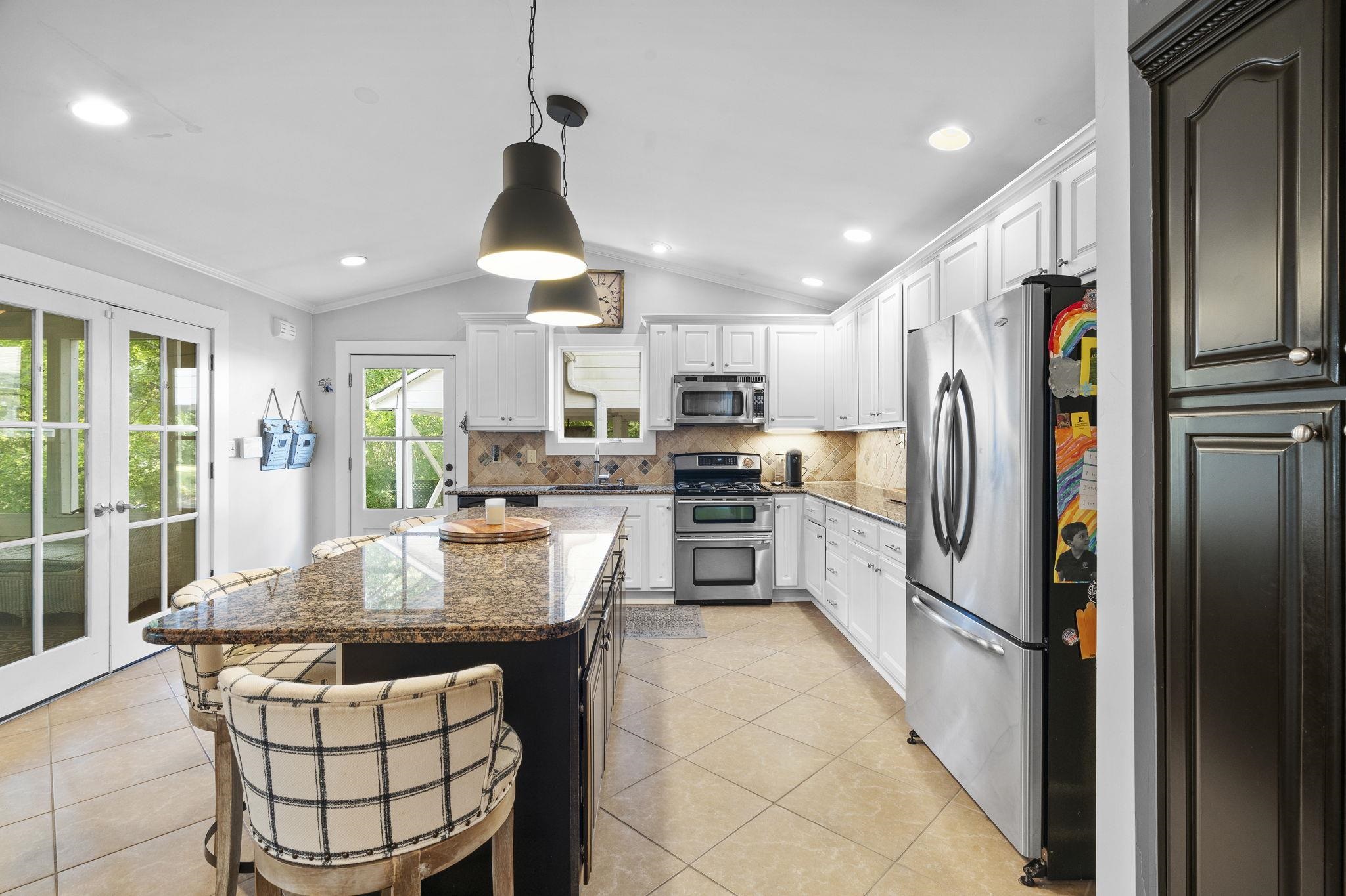 549 Peterson Lake Road Collierville, TN 38017 - Photo 8 of 34 a kitchen with granite countertop a refrigerator a stove a sink cabinets and a dining table