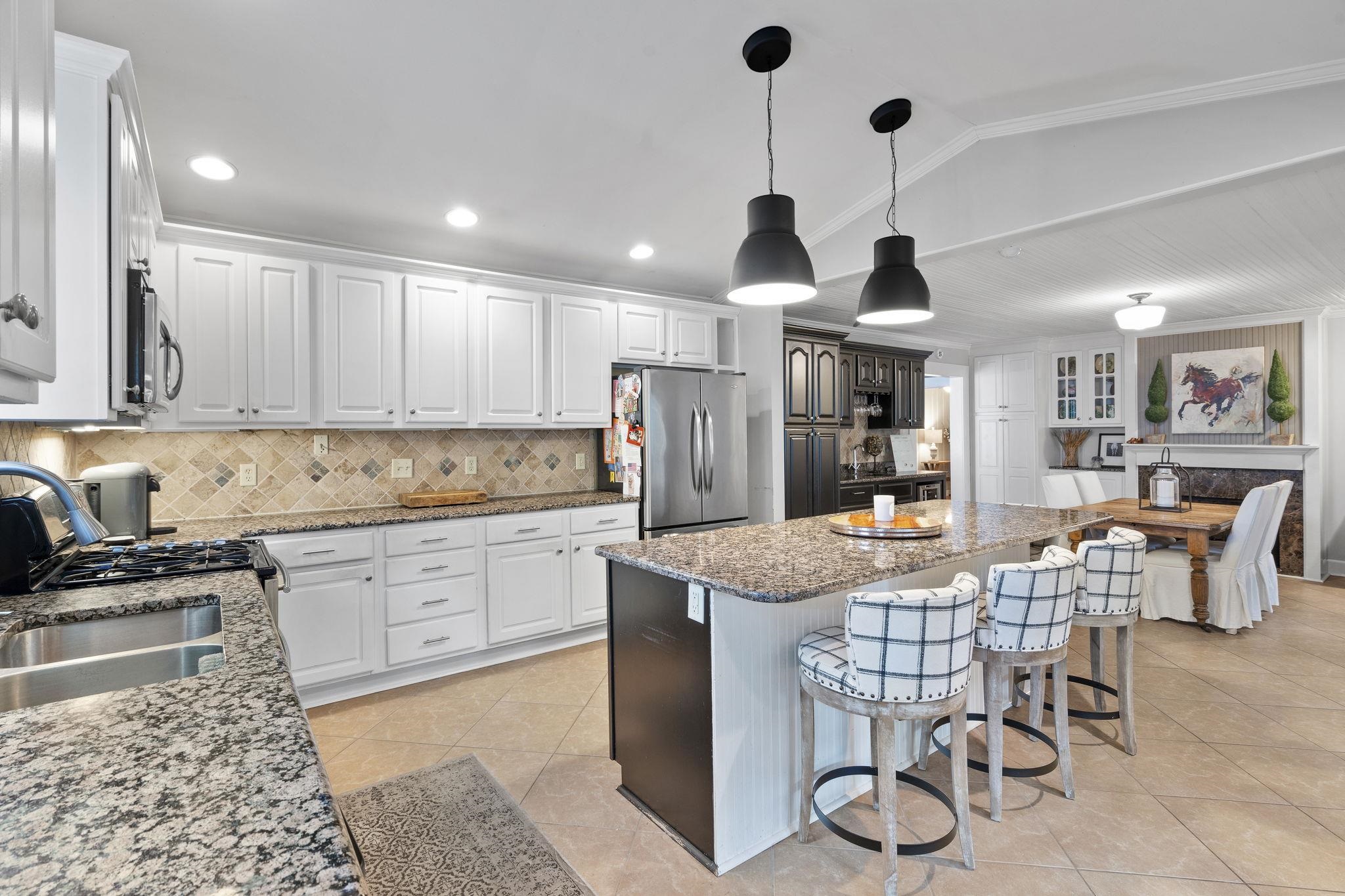 549 Peterson Lake Road Collierville, TN 38017 - Photo 10 of 34 a kitchen with stainless steel appliances granite countertop a sink a stove a dining table and chairs