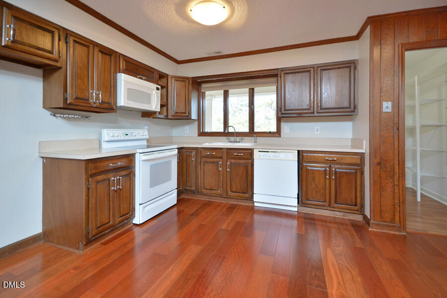 401 Martindale Drive Raleigh, NC 27614 - Photo 13 of 35 a kitchen with stainless steel appliances granite countertop wooden cabinets a sink and dishwasher with wooden floor