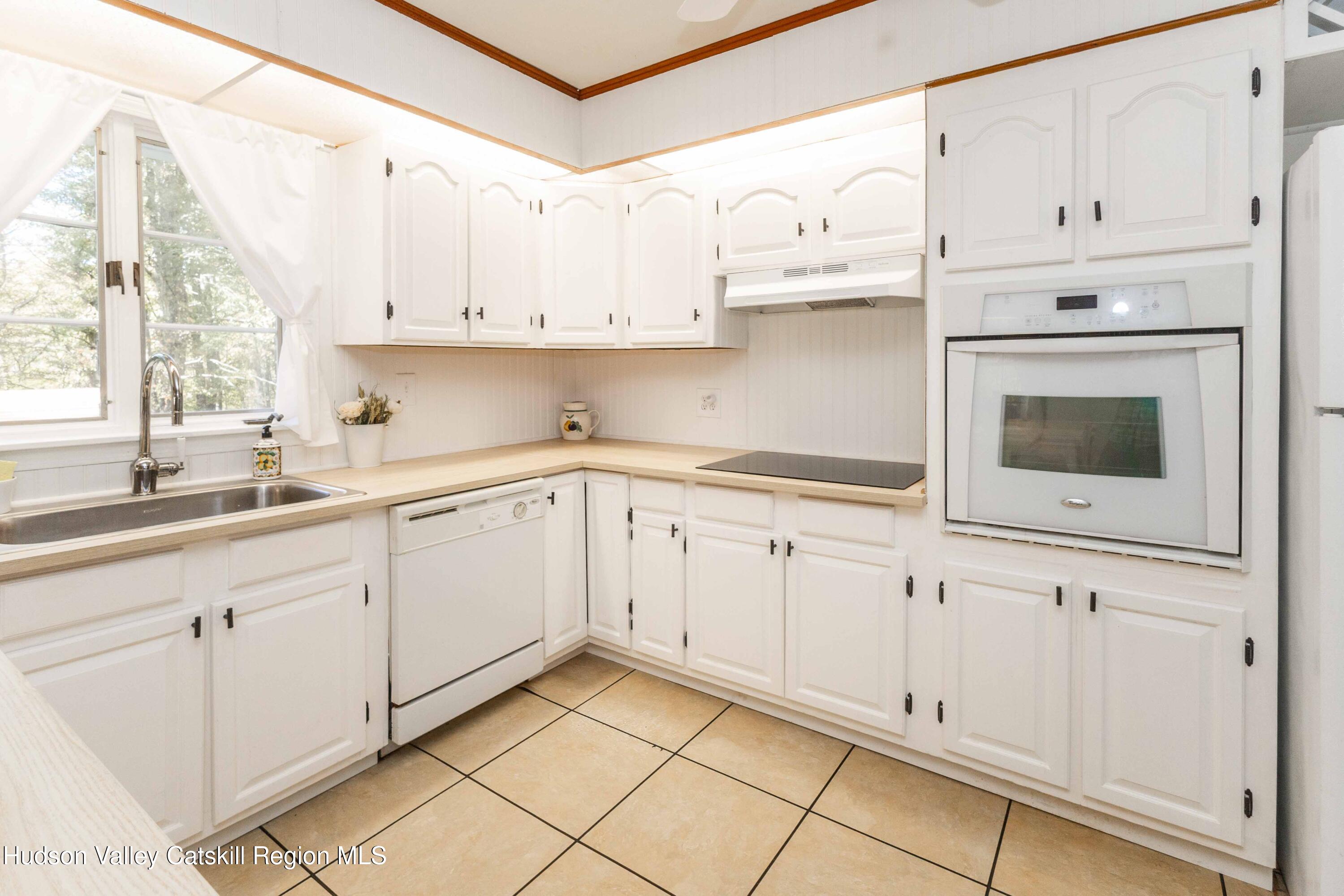 94 Lodge Road Saugerties, NY 12477 - Photo 16 of 46 a kitchen with white cabinets stainless steel appliances and a sink