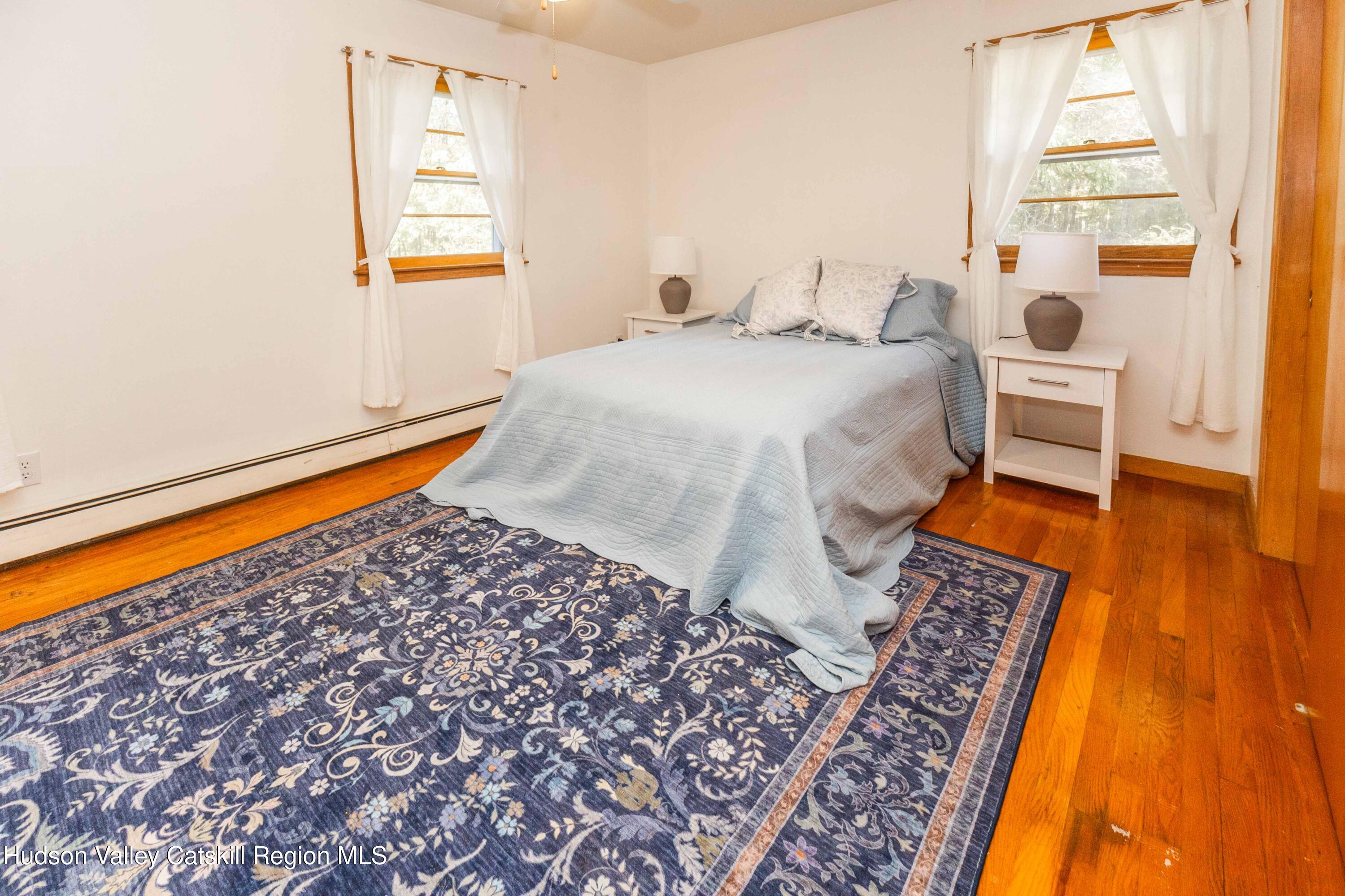94 Lodge Road Saugerties, NY 12477 - Photo 26 of 46 a bedroom with a bed and wooden floor