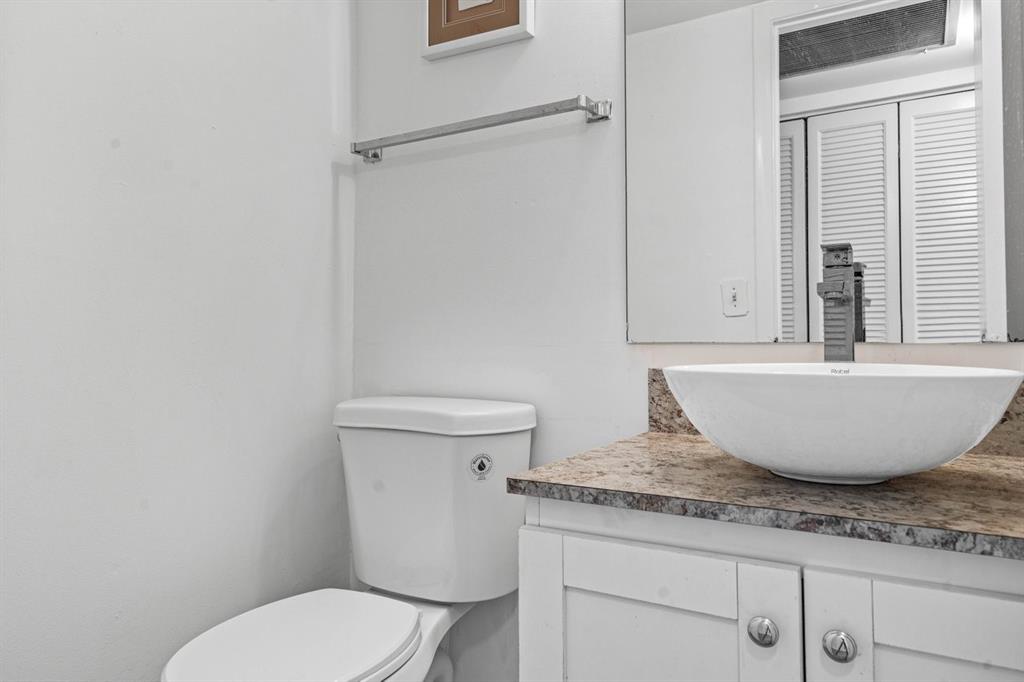 1038 Cambridge B, Unit 1038 Deerfield Beach, FL 33442 - Photo 14 of 22 a white toilet sitting next to a bathroom sink
