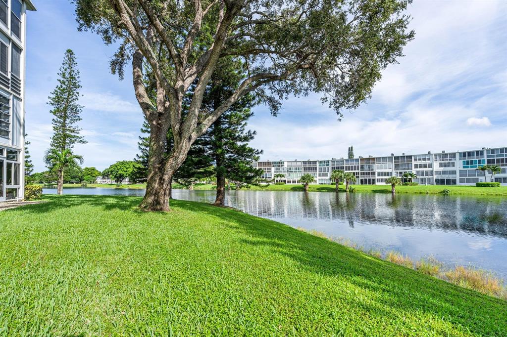 1038 Cambridge B, Unit 1038 Deerfield Beach, FL 33442 - Photo 20 of 22 a view of a lake with a house in the background