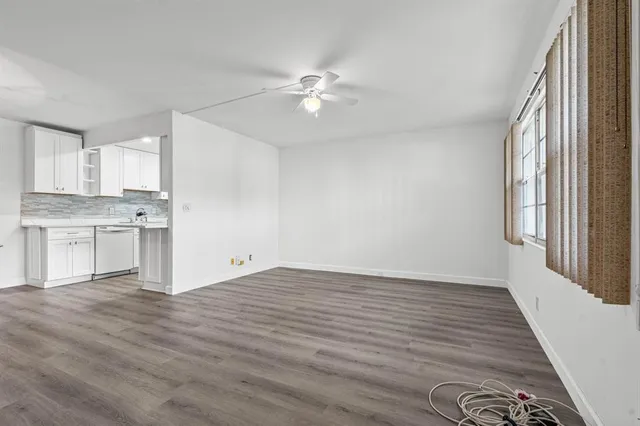 a view of a kitchen with wooden floor and a ceiling fan