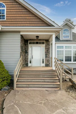 a view of a house with large windows and stairs