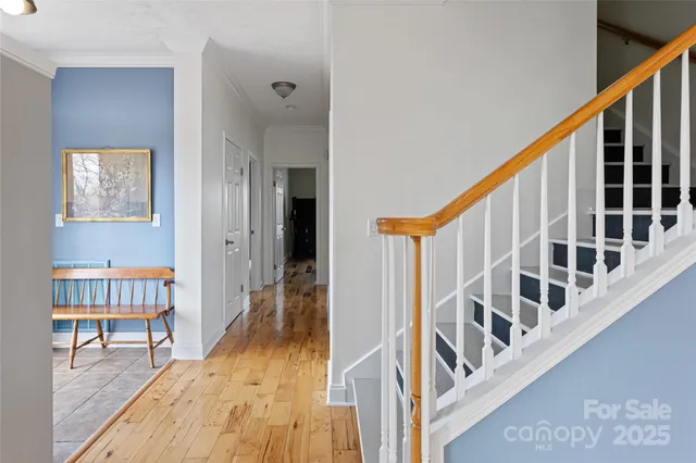a view of staircase with lots of frames on wall and a dining table