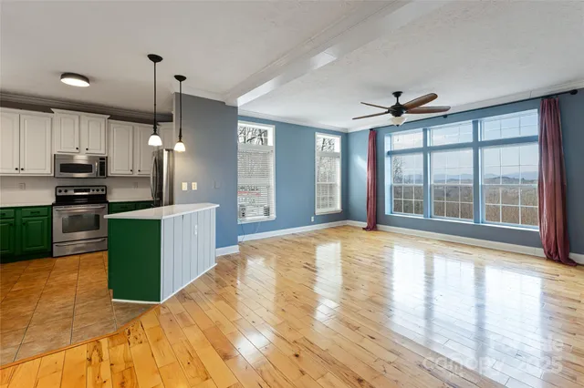 a view of a kitchen with kitchen island a sink and a large window