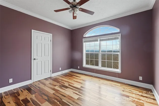 a view of a room with wooden floor and a window