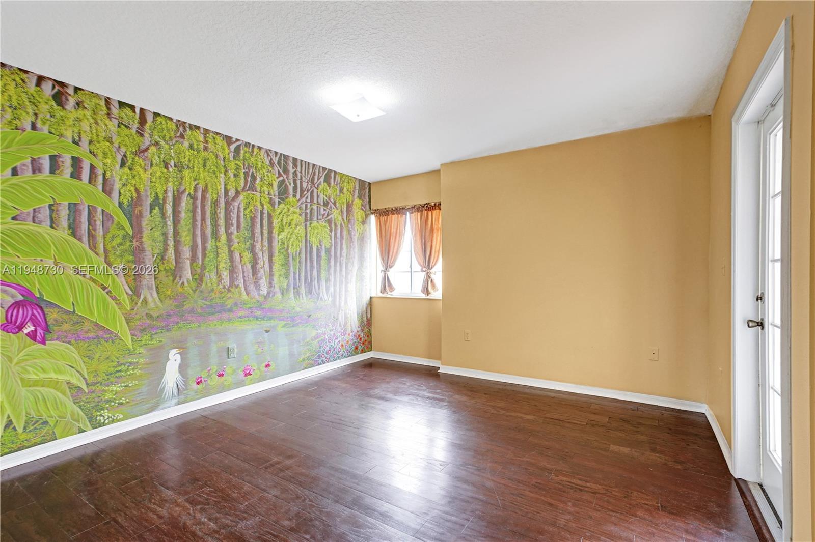 5502 Southwest 162nd Place Miami, FL 33185 - Photo 45 of 72 a view of an empty room with a window and wooden floor