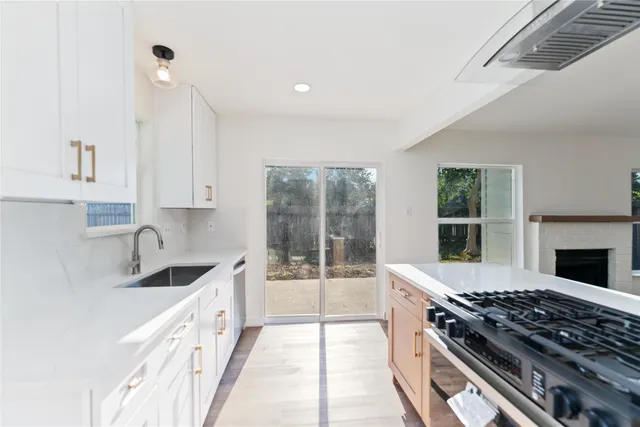 a kitchen with granite countertop a sink and a stove top oven