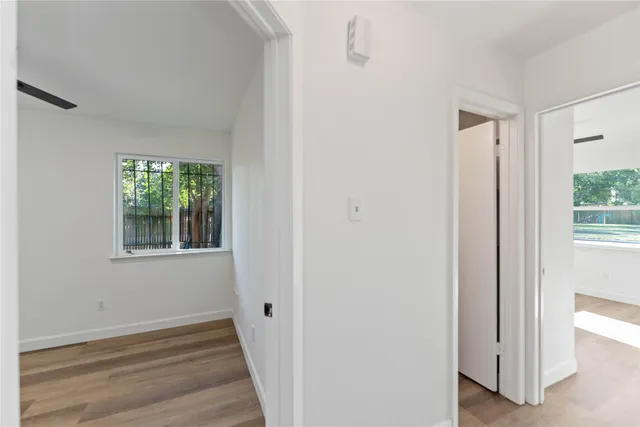 a view of a hallway with window and wooden floor