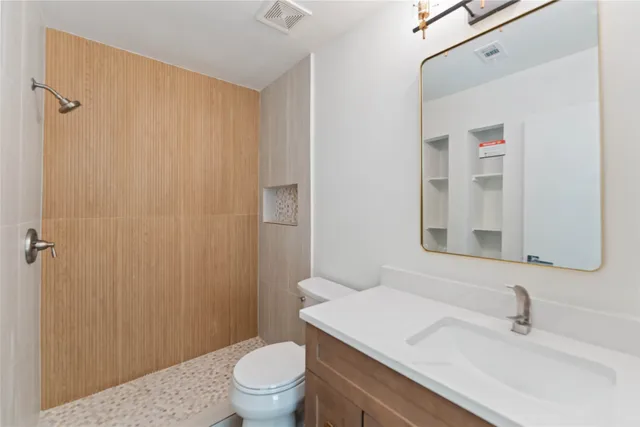 a bathroom with a sink a toilet and shower