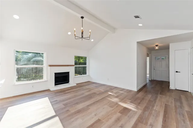 a view of empty room with wooden floor and fireplace