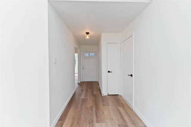 a view of a hallway with wooden floor