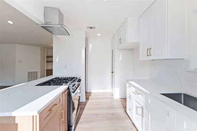 a kitchen with stainless steel appliances a stove a sink and a refrigerator