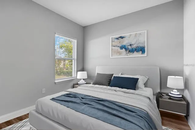 a bedroom with a bed and a painting on the wall