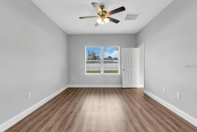 wooden floor in an empty room with a window