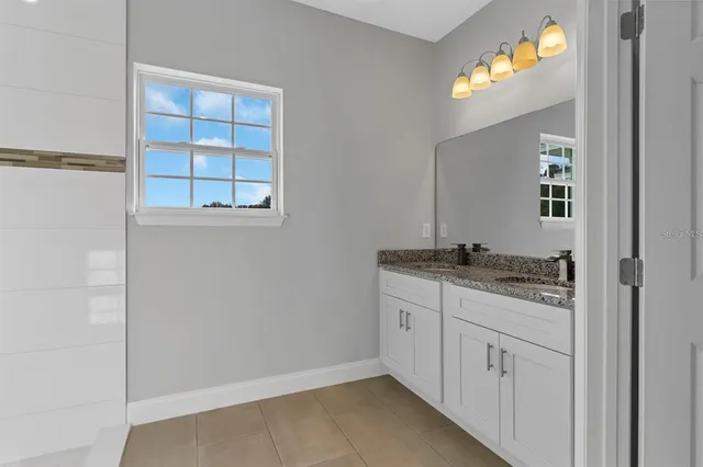 a bathroom with a granite countertop sink and a mirror
