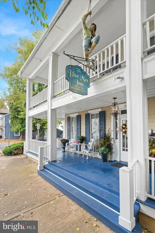 a view of a brick house with a large windows plants and large trees