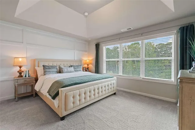 a bed sitting in a spacious bedroom next to a window