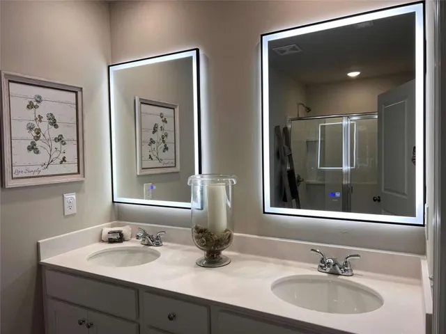 a bathroom with double vanity sinks and a mirror