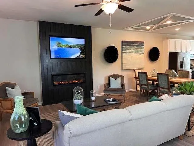 a living room with furniture a flat screen tv and a fireplace