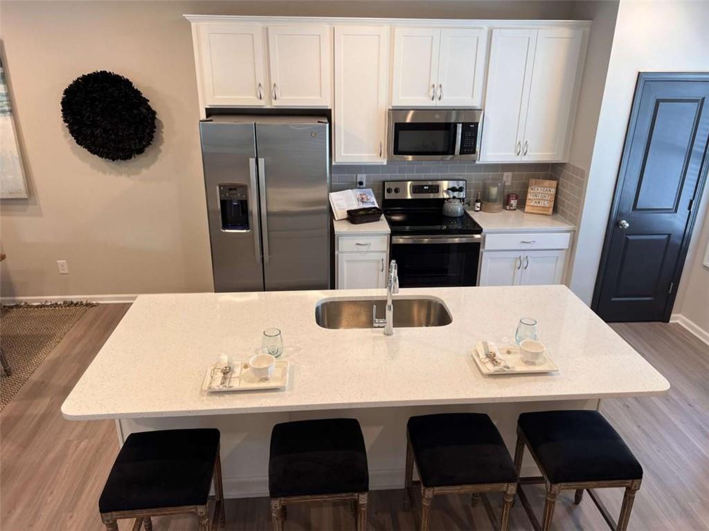 35 Cobalt Lane Newnan, GA 30265 - Photo 8 of 19 a kitchen with a sink a microwave a refrigerator and cabinets