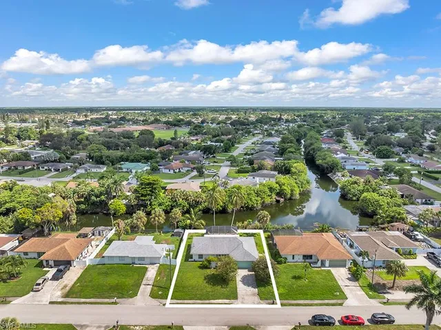 an aerial view of residential houses with outdoor space and lake view
