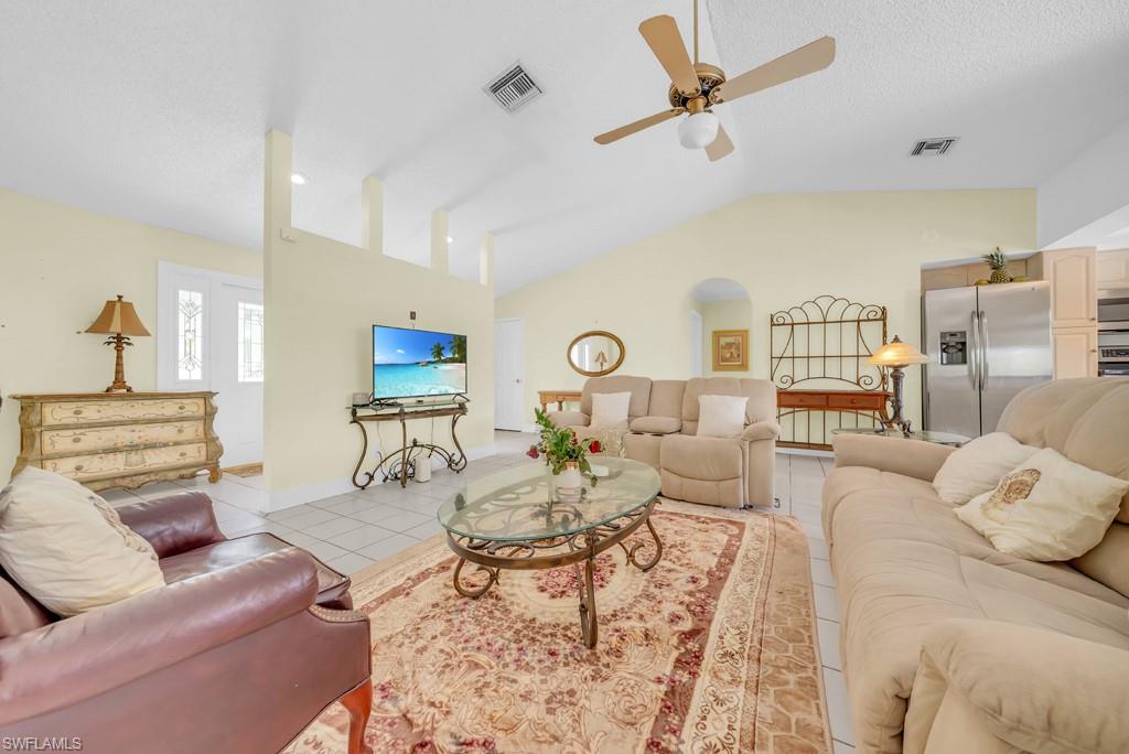 4736 25th Avenue Southwest Naples, FL 34116 - Photo 6 of 26 a living room with furniture a rug and a chandelier
