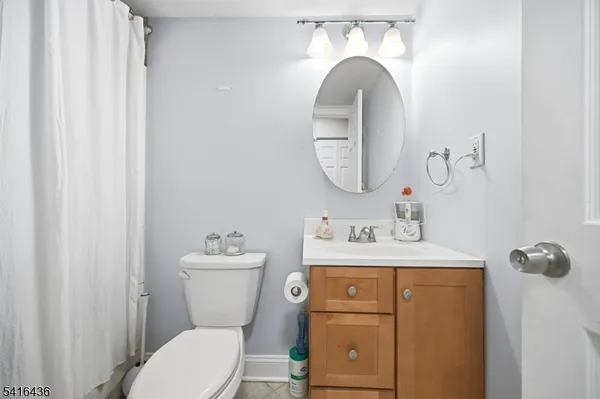 a bathroom with a toilet sink vanity and mirror