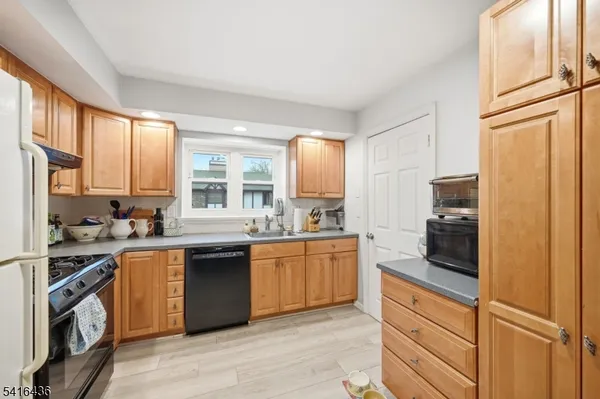 a kitchen with granite countertop stainless steel appliances and wooden cabinets