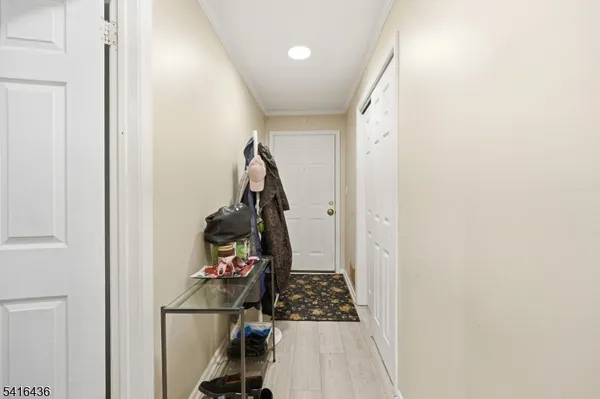 a walk in closet with wooden floor